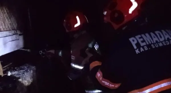 Petugas Damkar memadamkan api di rumah panggung Cilembu Sumedang