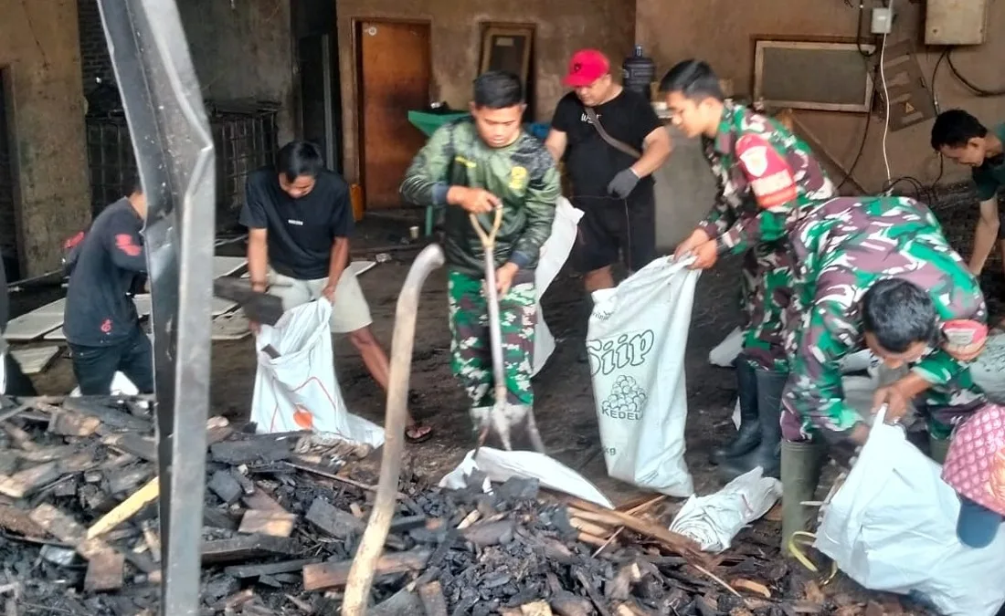 Babinsa Koramil Tanjungsari bantu warga bersihkan sisa kebakaran pabrik tahu Pamulihan pada Minggu (17/5/2026)