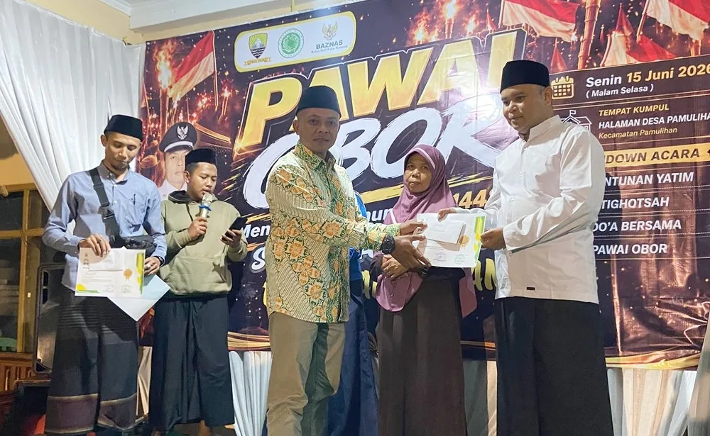 Kepala Desa Pamulihan, Ujang Sulaeman memberikan Penghargaan Kencleng Simpai BAZNAS kepada Ketua RT dalam acara peringatan Tahun Baru Islam 1 Muharram 1448 Hijriyah