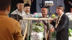 Penyerahan hasil bumi secara simbolis dari masyarakat kepada Kepala Desa Haurngombong, Dadang di acara Milangkala ke-44 pada Senin (22/6/2026)