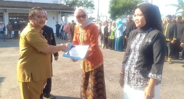 Asda Bidang Pamkesra, Dr. Dian Sukmara memberikan penghargaan pada upacara Peringatan Harganas 2026