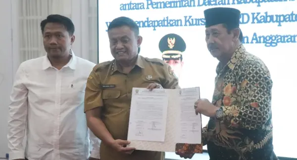 Plt. Kepala Badan Kesatuan Bangsa dan Politik (Kesbangpol) Kabupaten Sumedang, Asep Rahmat Hidayat menyerahkan NPHD bantuan keuangan parpol Sumedang 2026