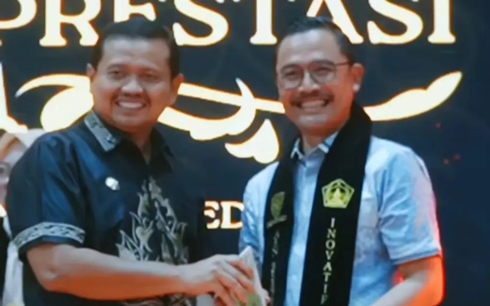 Bupati Sumedang, Dony Ahmad Munir menyerahkan penghargaan kepada Eka Ganjar Kurniawan (Kepala Dinas Pendidikan) sebagai ASN Inovatif