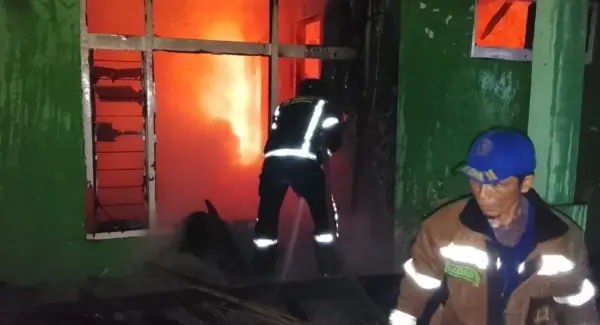 Petugas Damkarmat Tanjungsari sedang berjibaku memadamkan api yang membakar rumah semi permanen di Rancabawang, Cinanjung Tanjungsari